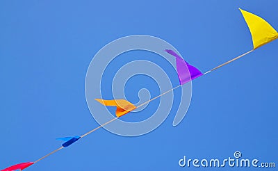 Multicolored triangular small flags to celebration party against blue sky.Street holiday concept for design. Stock Photo