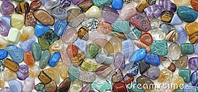 Multicolored tumbled crystal stones background Stock Photo