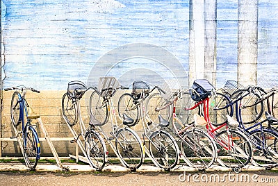 Multicolored vintage bicycles in metal rack in Tokyo city Stock Photo