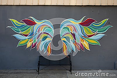 Multicolored wings above a black iron bench for self photographs in historic downtown Sherman, Texas. Editorial Stock Photo
