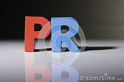 Multicolored word PR made of wood. Stock Photo