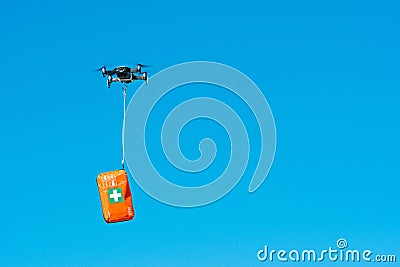Multicopter drone flying with a first aid kit isolated on a blue sky, emergency medical care concept Stock Photo