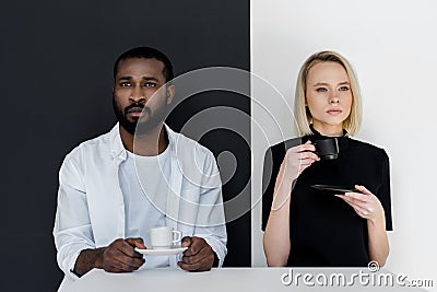 multicultural couple holding cups of coffee Stock Photo