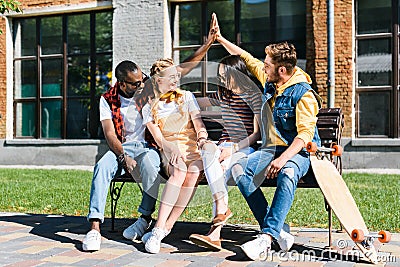 multicultural couples resting on bench together Stock Photo