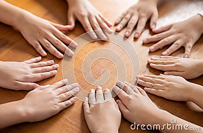 Multicultural hands man woman children in circle on brown wooden background. Stock Photo