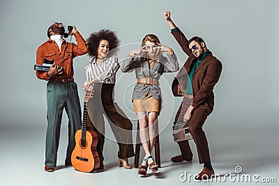 multicultural retro styled friends having fun with guitar and vintage electronics Stock Photo