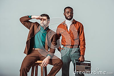 multicultural retro styled friends with pipe and radio looking away Stock Photo