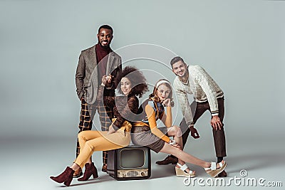 multicultural retro styled friends posing with vintage television Stock Photo