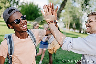 Multiethnic boys giving high five while meeting in park Stock Photo
