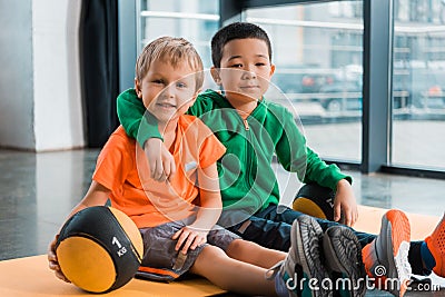 Multiethnic boys looking at camera, hugging Stock Photo