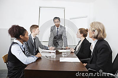 Multiethnic businesspeople at meeting in conference room Stock Photo