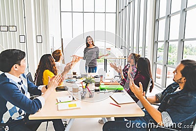 Multiethnic diverse group of creative team or business coworker clap hands in project presentation meeting leading by Asian woman Stock Photo