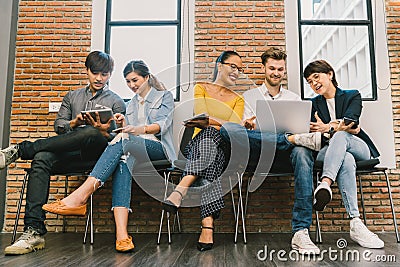 Multiethnic diverse group of young and adult people using smartphone, laptop computer, digital tablet together Stock Photo