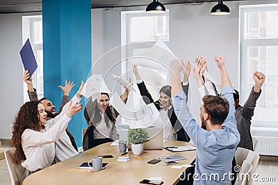 Multiethnic diverse happy team celebrate project success throw paper up together. Corporate community, college graduation, startup Stock Photo