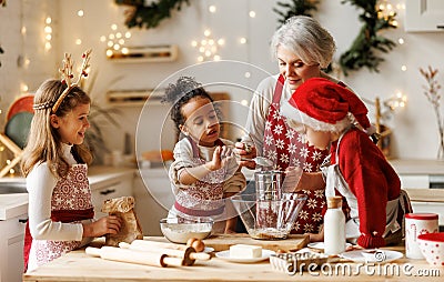 Multiethnic family, grandmother and three little kids, cooking Christmas cookies together in kitchen Stock Photo