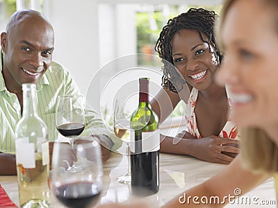 Multiethnic Friends With Wineglasses At Table Stock Photo