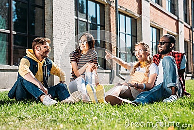 multiethnic group of friends resting on green grass Stock Photo