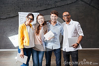 Multiethnic group of happy young business people standing in office Stock Photo