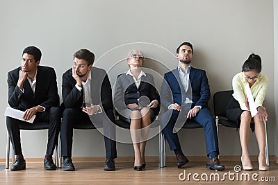 Multiethnic job candidates tired of waiting in queue for intervi Stock Photo