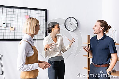 Multiethnic office workers gesturing and talking Stock Photo