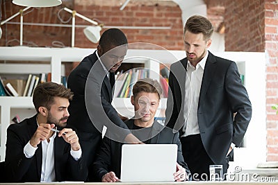 Multiethnic team of corporate employees looking at laptop screen Stock Photo
