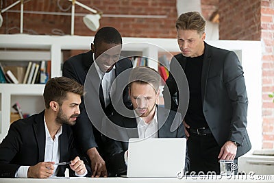 Multiethnic team of corporate employees looking at laptop screen Stock Photo