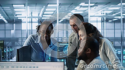 Multiethnic team of engineers working in high tech server hub, Stock Photo