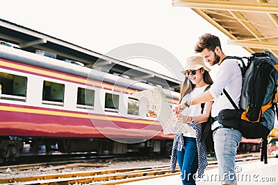 Multiethnic traveler couple using generic local map navigation together at train station platform. Asia tourism trip concept Stock Photo