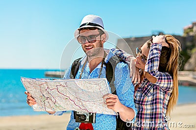 Multiethnic traveler couple using generic local map together on sunny day. Stock Photo