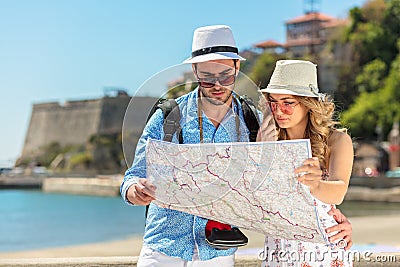 Multiethnic traveler couple using generic local map together on sunny day. Stock Photo