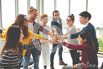 Multiethnic young team stack hands together as unity and teamwork in modern office. Diverse group togetherness collaboration Stock Photo