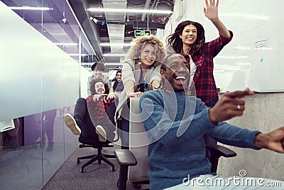 Multiethnics business team racing on office chairs Stock Photo