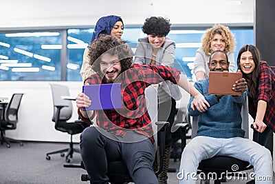Multiethnics business team racing on office chairs Stock Photo