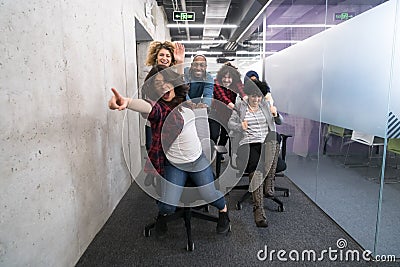 Multiethnics business team racing on office chairs Stock Photo