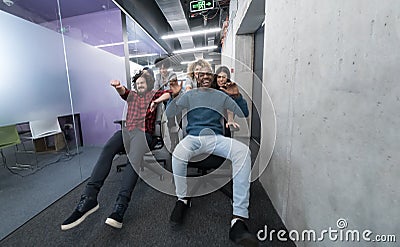 Multiethnics business team racing on office chairs Stock Photo