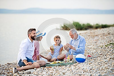 Multigeneration family on a holiday by the lake, having picnic. Stock Photo