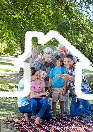 Multigeneration family taking a selfie outdoor against house outline in background Stock Photo