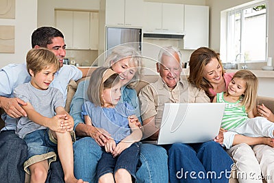 Multigeneration family using laptop in living room Stock Photo