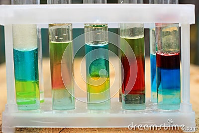 Multilayer systems of colored liquid insoluble substances in test tubes. Stock Photo