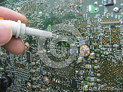 Multimeter probes examining a circuit board Stock Photo