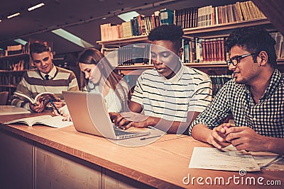 Multinational group of cheerful students studying in the university library. Stock Photo