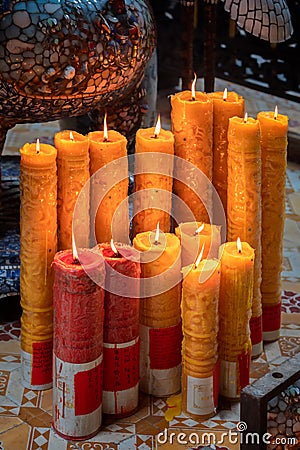 Multiple candles with flames inside temple in Ho Chi Minh city Stock Photo