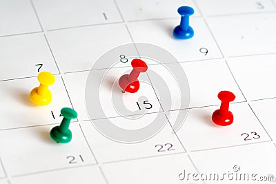 Multiple color pins on calendar grid Stock Photo