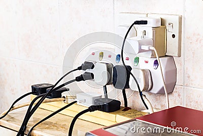 Multiple electricity plugs on adapter risk overloading and dange Stock Photo