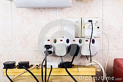 Multiple electricity plugs on adapter risk overloading and dange Stock Photo