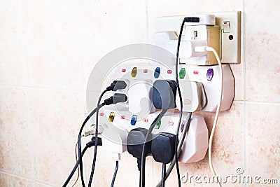 Multiple electricity plugs on adapter risk overloading and dange Stock Photo