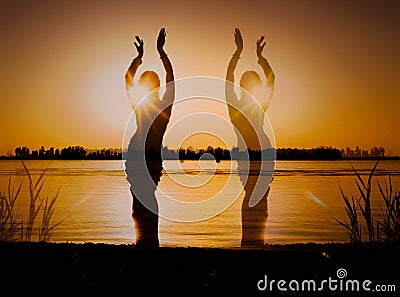 Multiple exposure of dark glowing silhouette of slim tribal dancer near big river Stock Photo