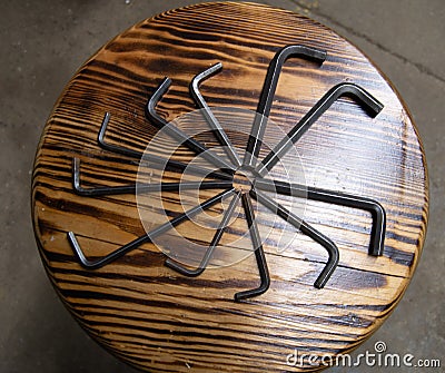 Multiple imbus hex keys forming a circle on a wooden texture background, concept of movem Stock Photo