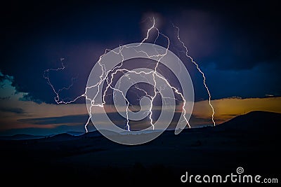 Multiple lightning strikes on distant mountain Stock Photo