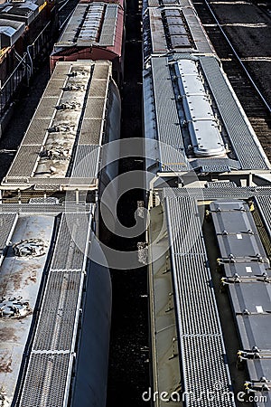 Multiple lines of covered hopper railroad train cars on tracks in trainyard Stock Photo